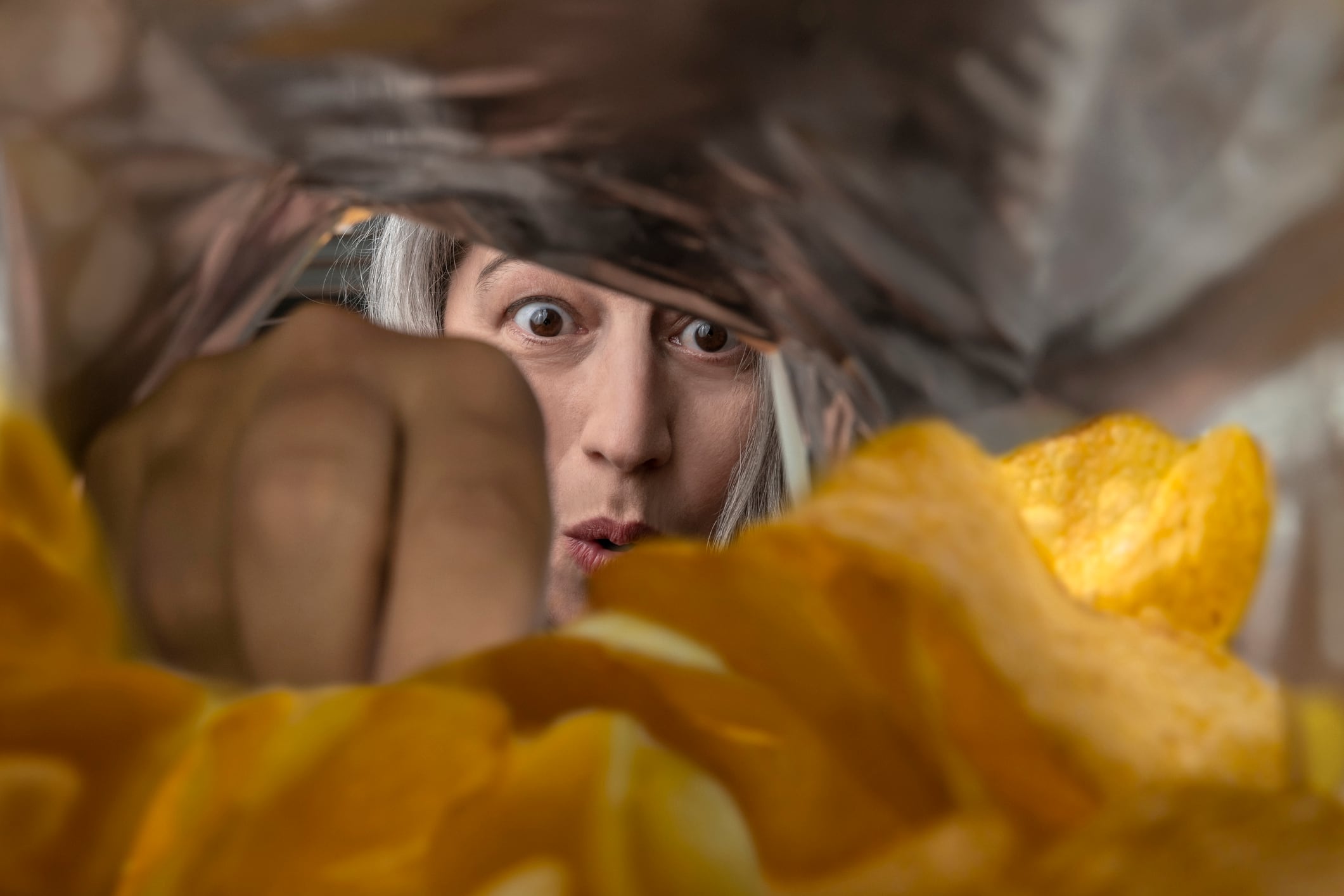 A woman eating chips from a package.