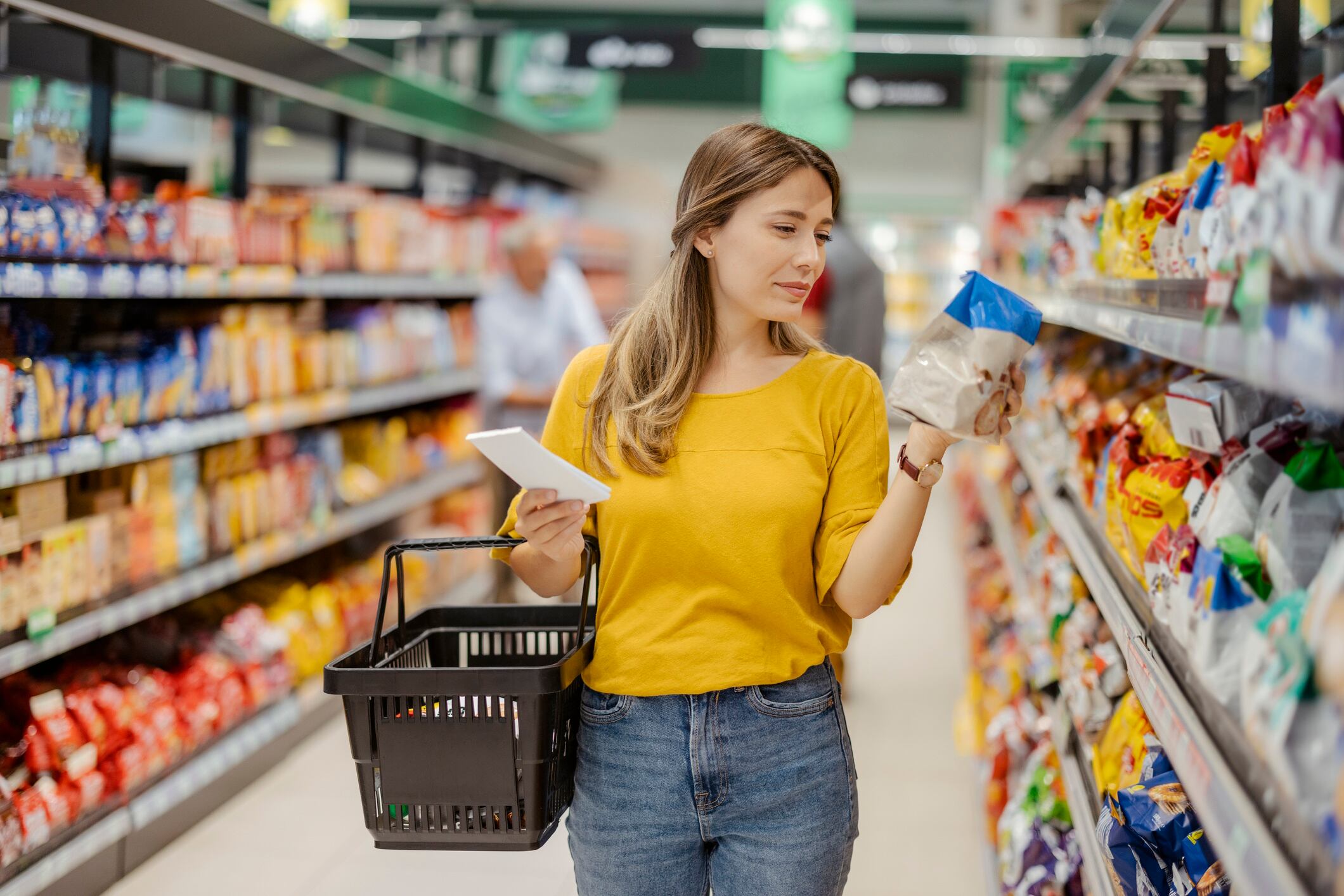 Woman looking at biscuit pack in supermarket