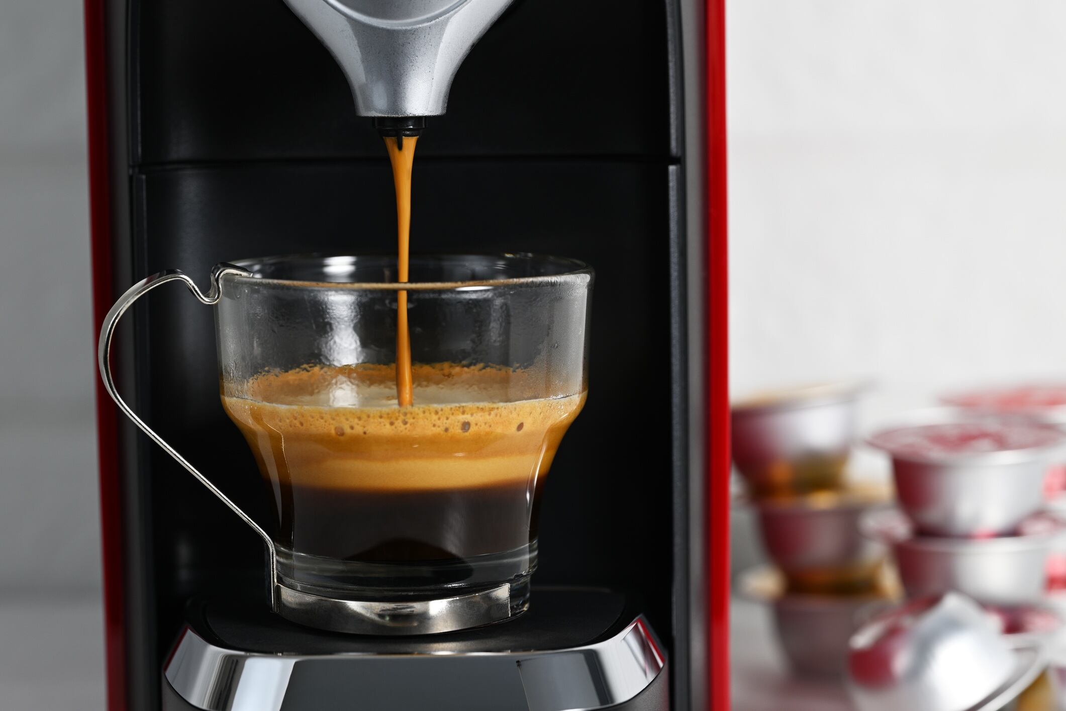 Espresso machine making coffee in glass cup.