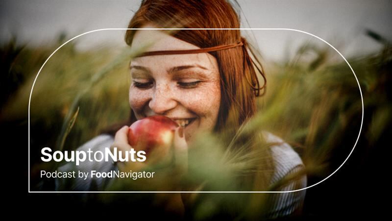 A happy woman bites into an apple