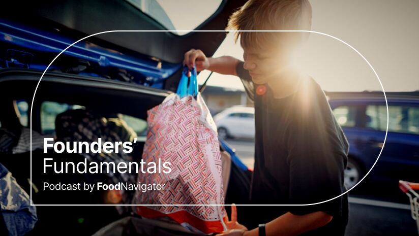 A teenage boy loads groceries into the trunk of a car