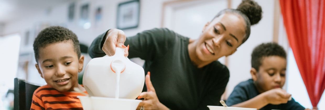 Woman pouring dairy milk to children