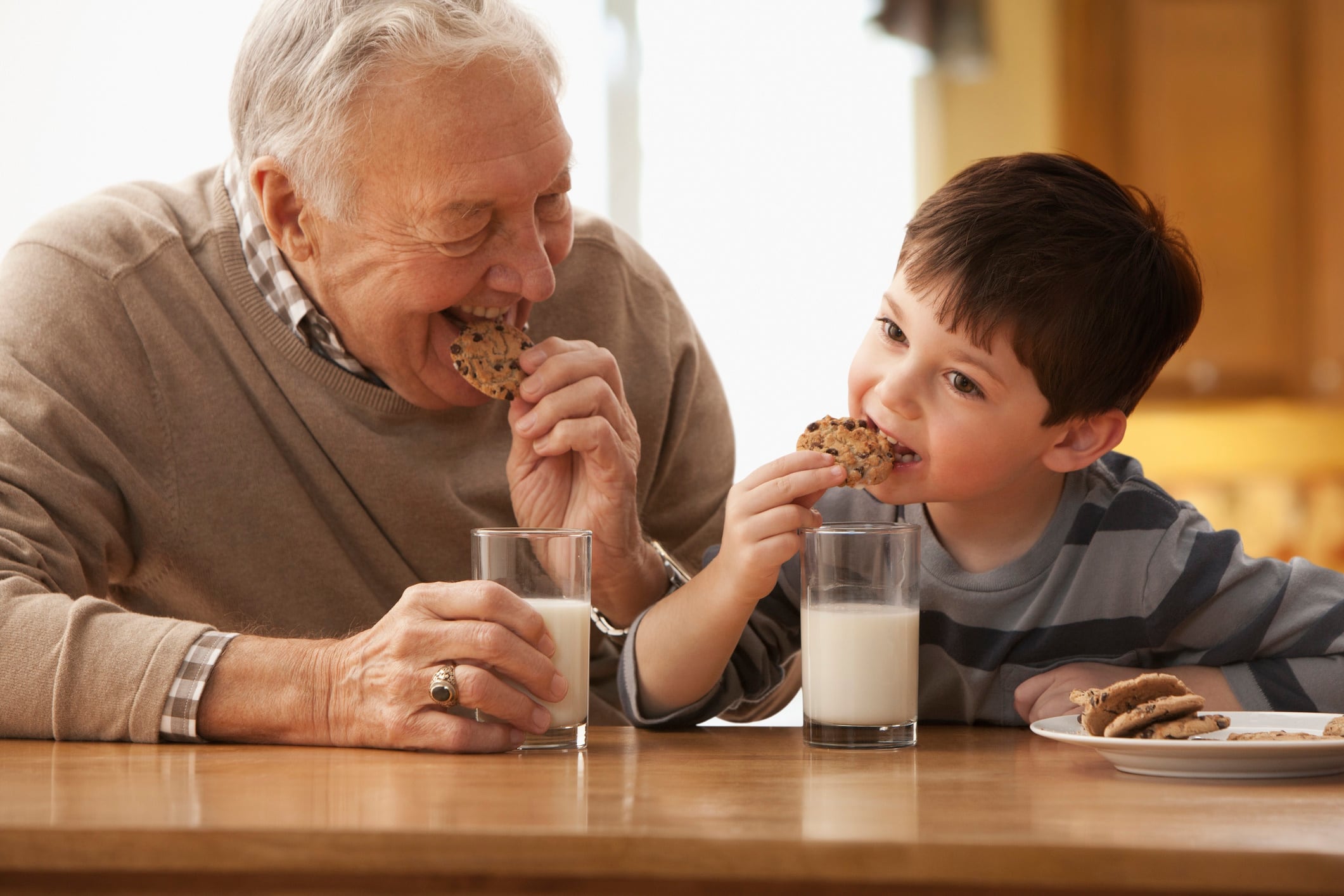 Grandfather and grandson eating milk and cookies