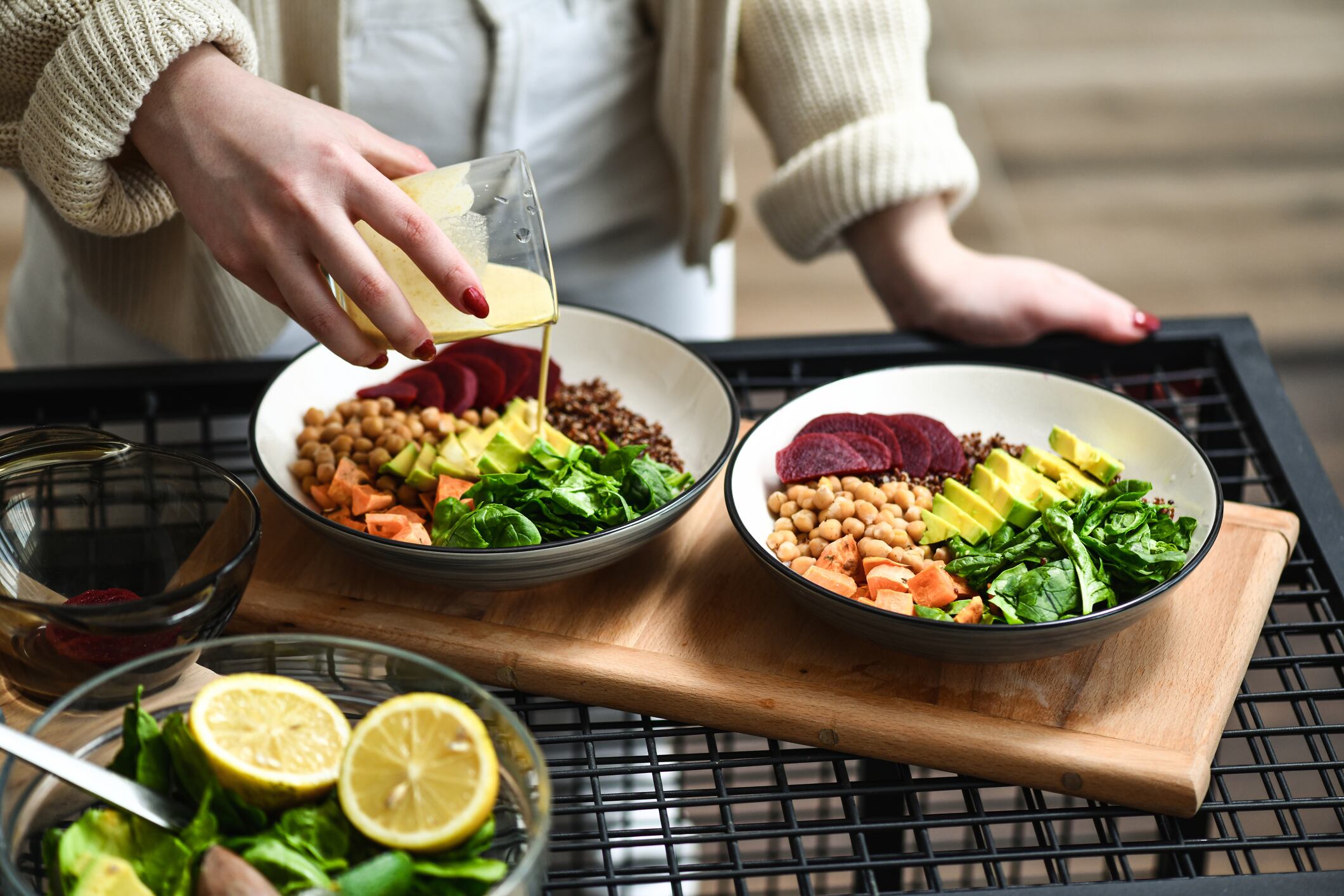 How will the food and drink sector evolve plant-based? Image: Female Preparing Aesthetically Pleasing Salad Bowls Adding Dressing on Top To Tie Flavors Together