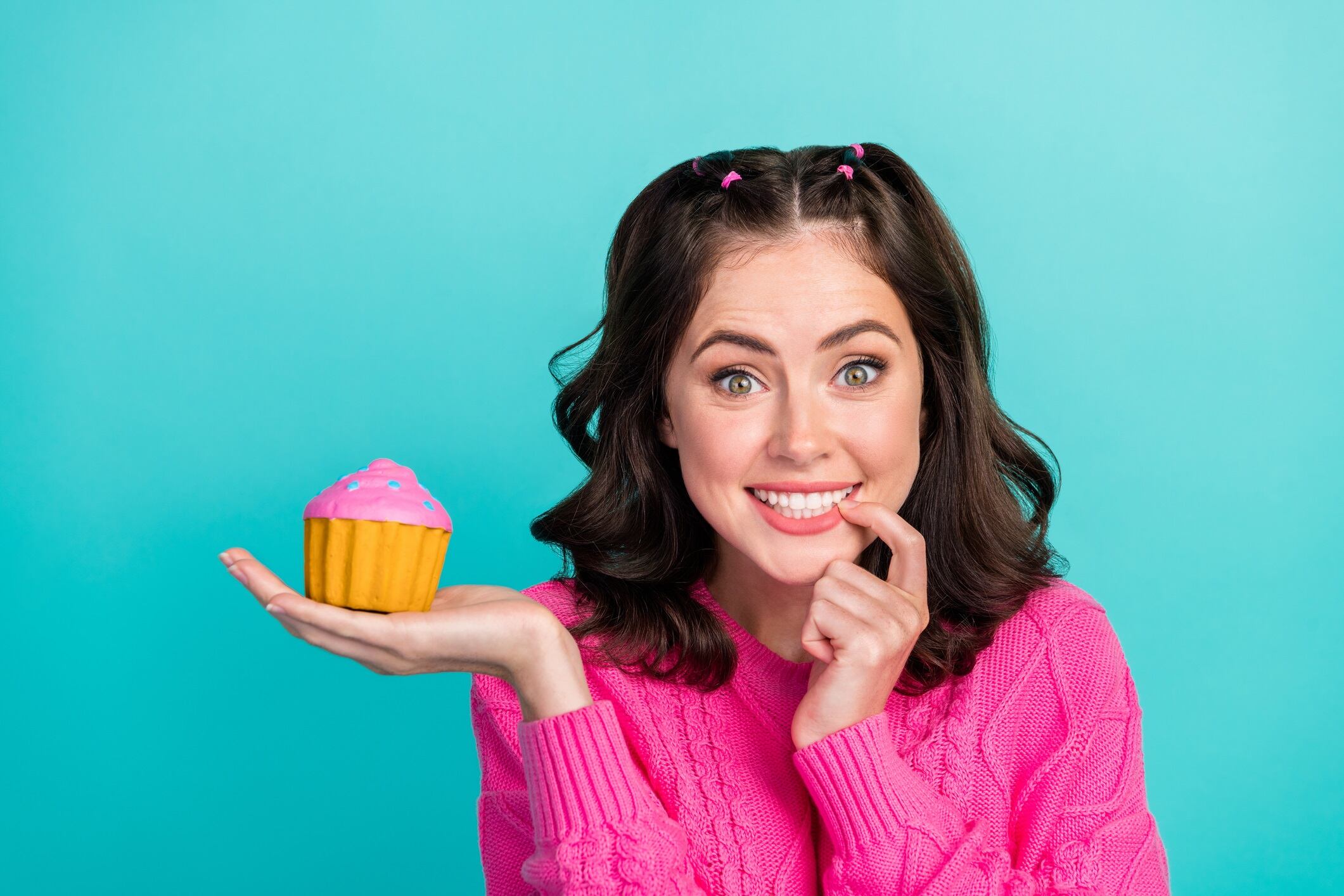 Woman holding cake on cyan colour background