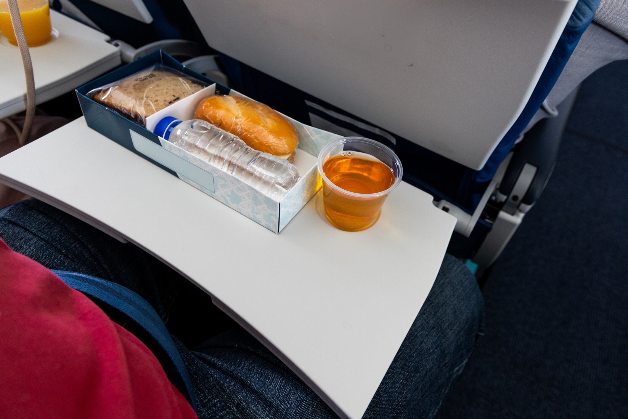 Simple mealbox with light snack, apple juice and water served in short haul flight in Malaysia ThamKC GettyImage