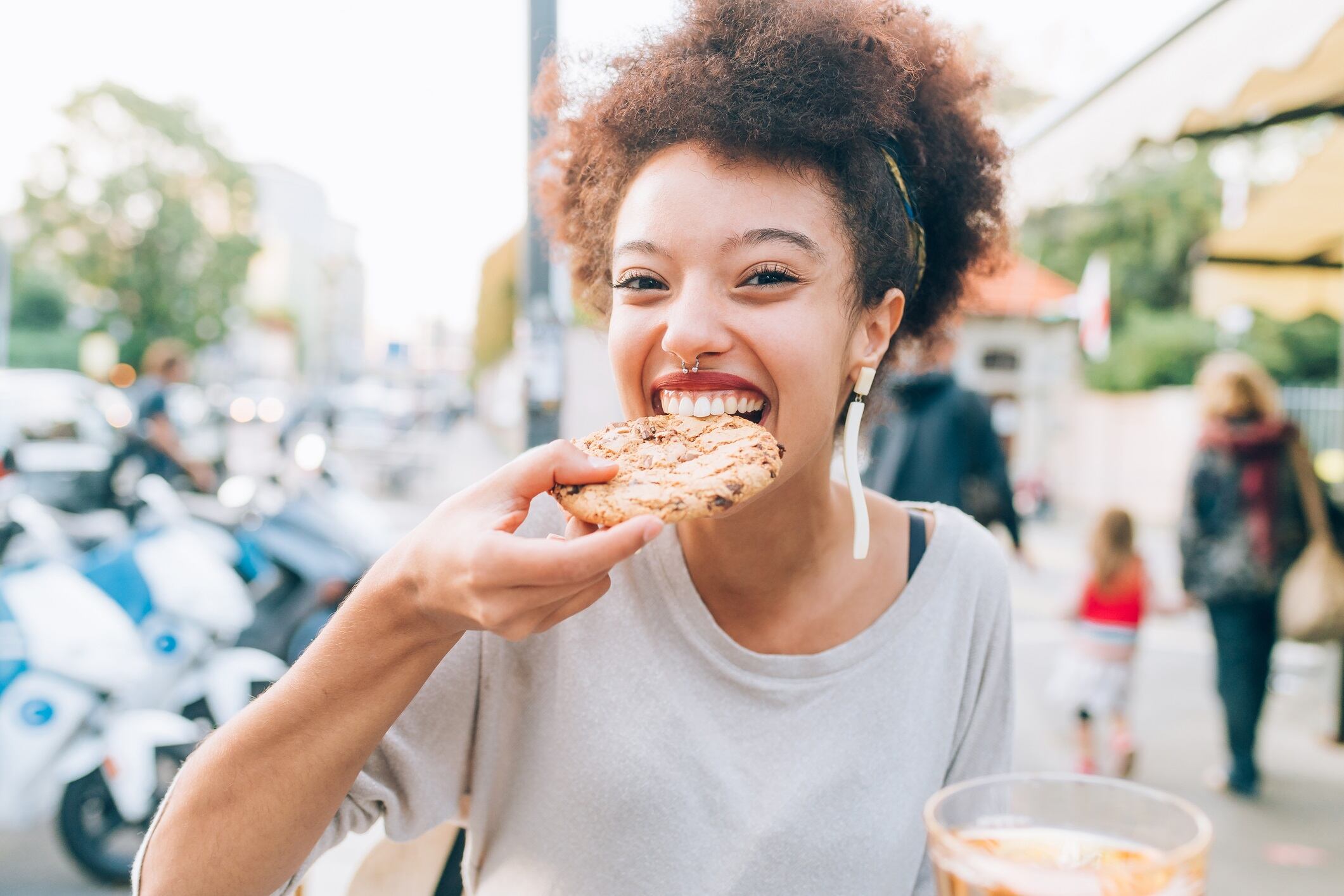 Young woman eating cookie at outdoor cafe
