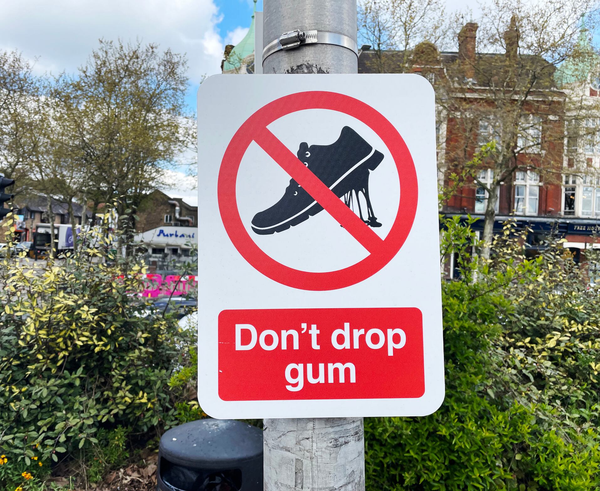 Sign asking people not to drop their chewing gum affixed to a lamppost in London. April 2023