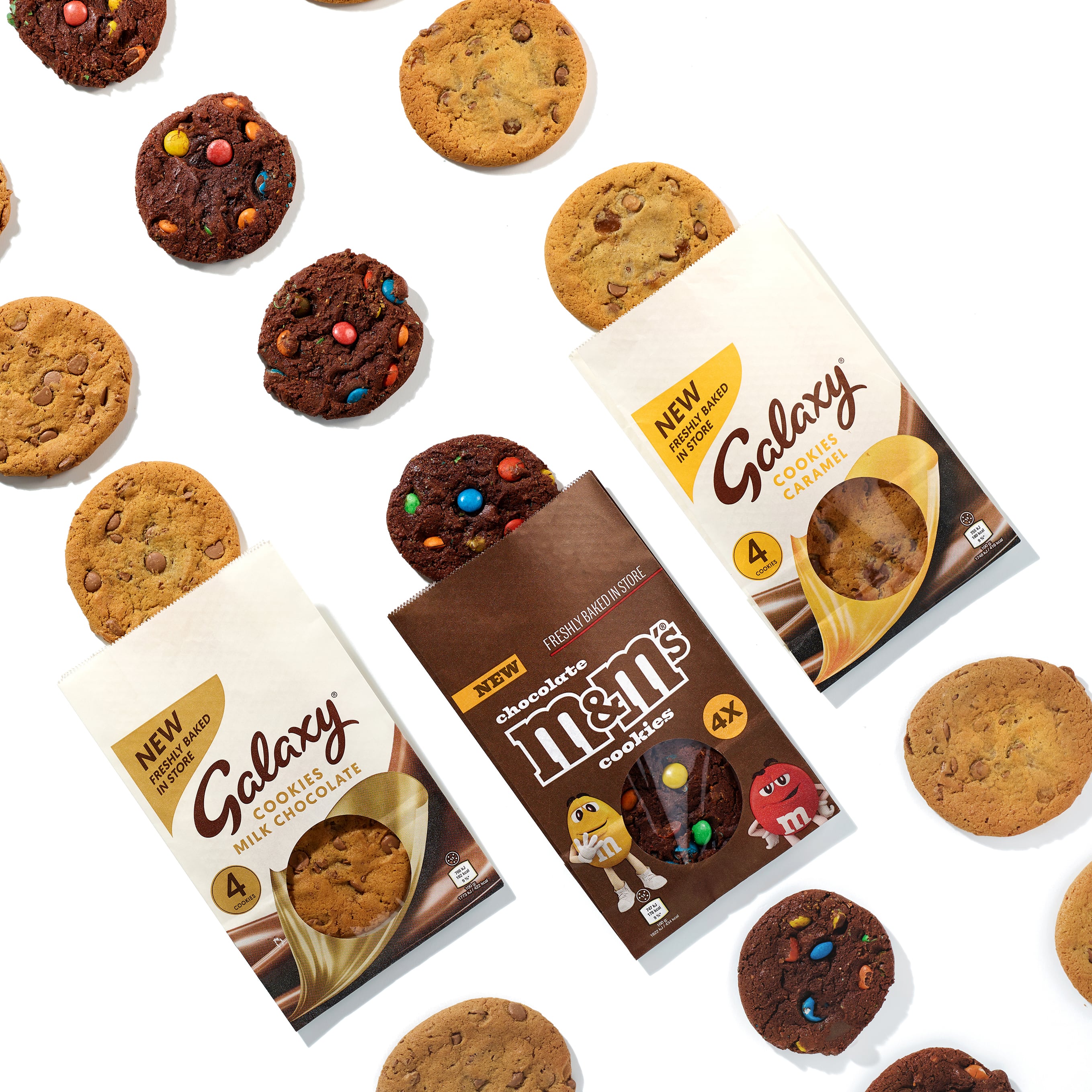 Mars innovations include Galaxy and M&M's cookies pictured in their packaging and spilled across a white surface.
