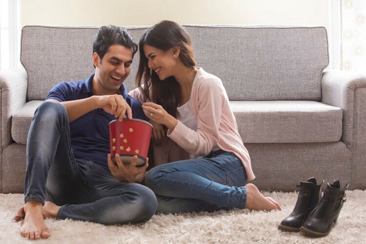 Young Indian couple eating snacks