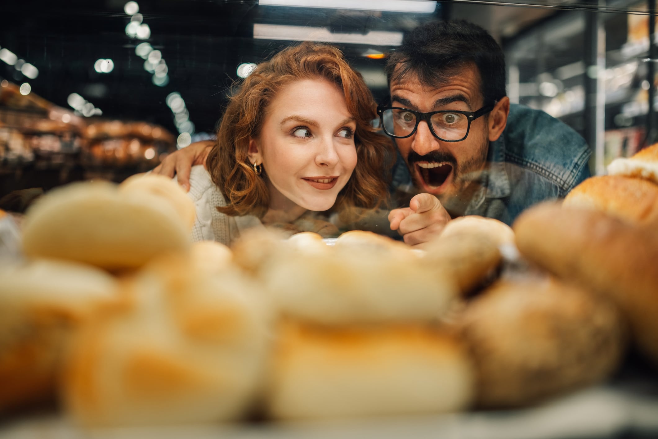 Couple choosing bread from bakery display