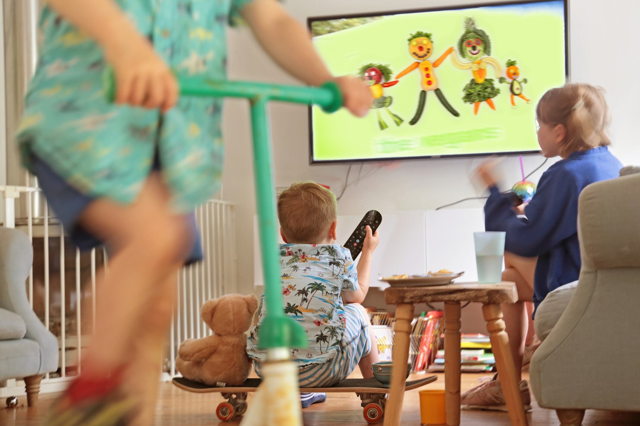 Children playing and watching TV in living room Peter Cade GettyImages