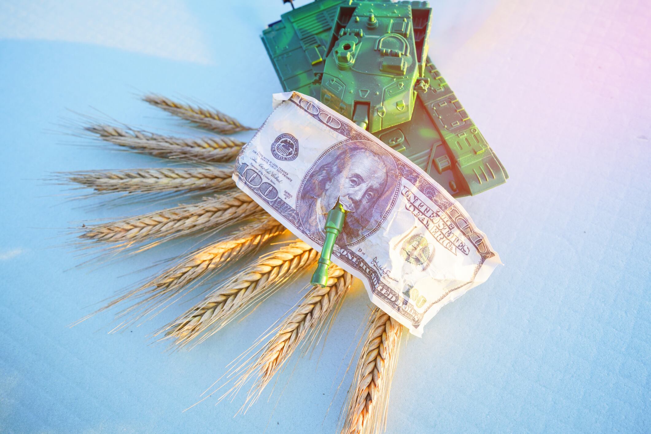 Battle tank on Wheat with US dollar banknotes. Maksim Safaniuk GettyImages