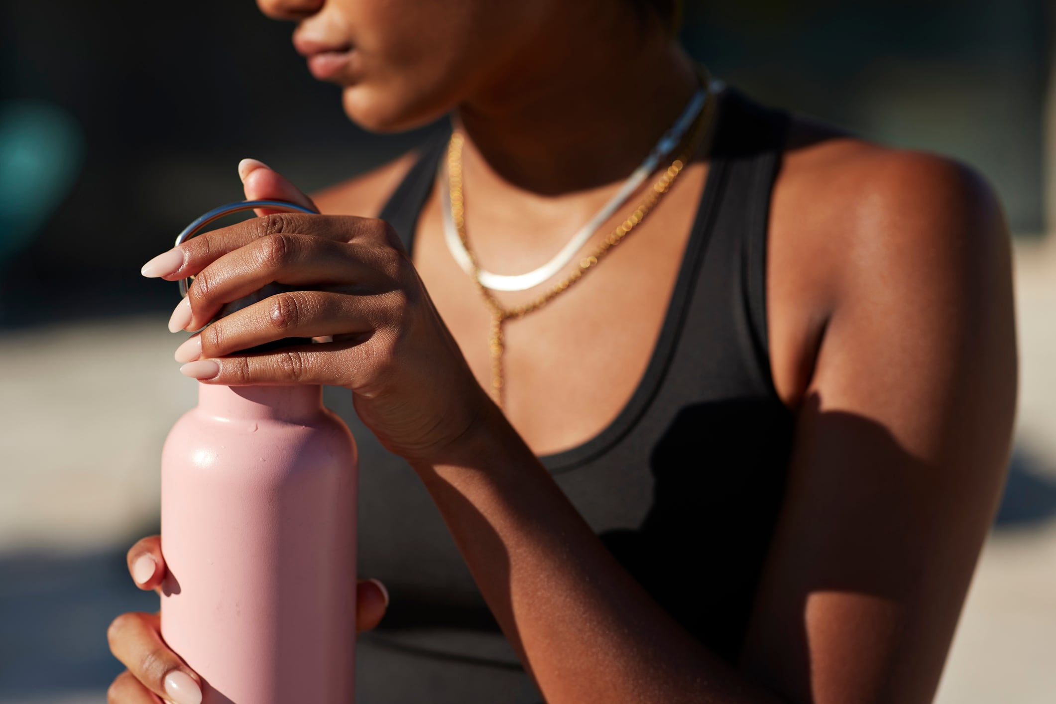 A healthy looking woman with a water bottle in the sunshine