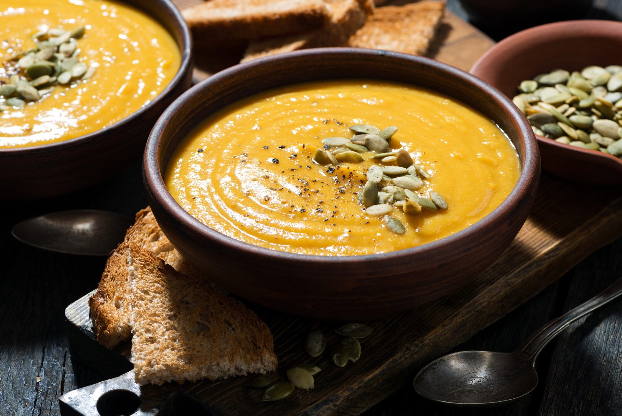 Delicious pumpkin soup on wooden table, closeup, horizontal