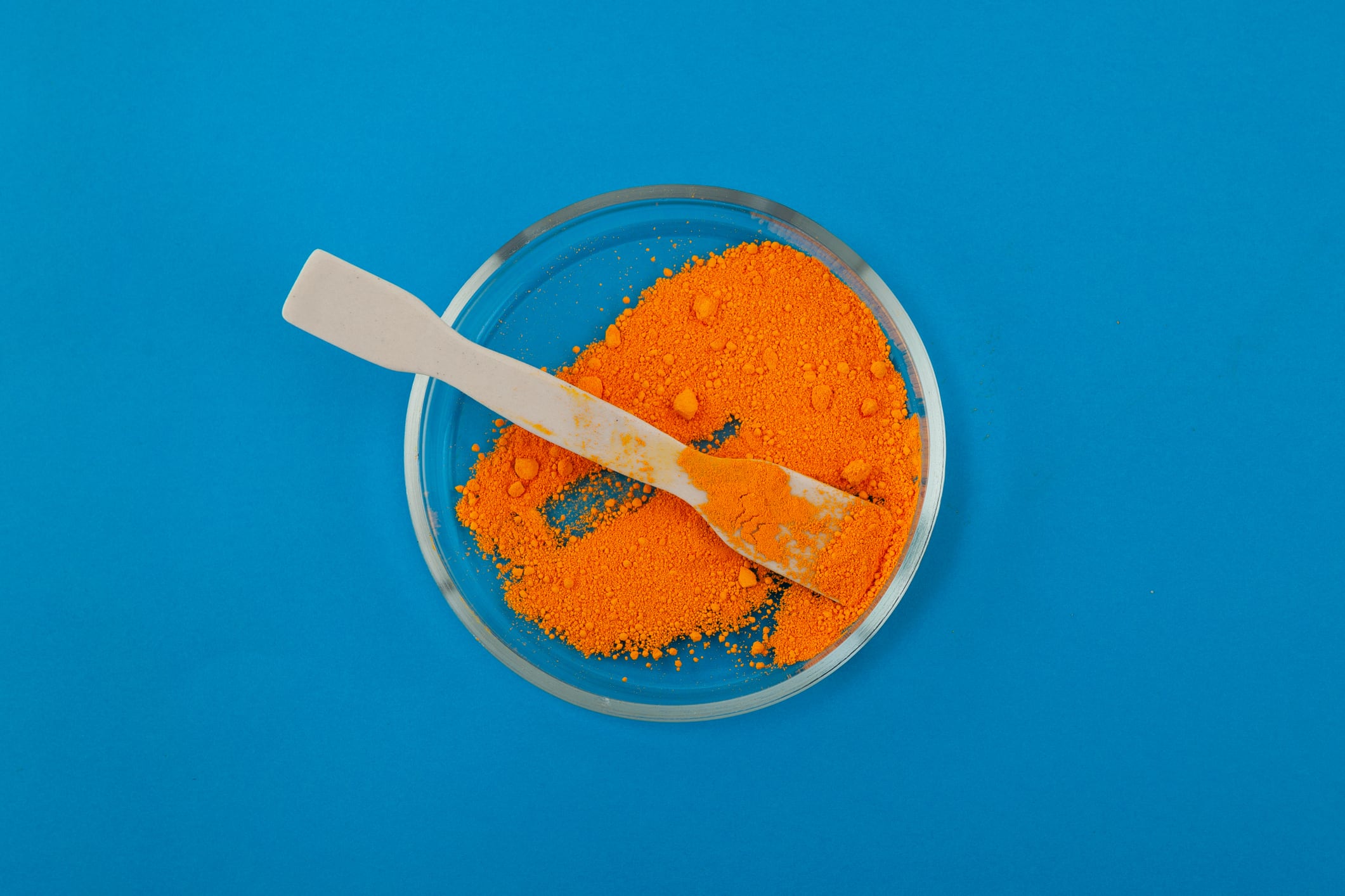 Tartrazine powder and ceramic spatula in Petri dish. Synthetic lemon yellow azo dye. Food additive E102. Tartrazine, usually labelled as CI 19140 or FD&C Yellow 5.