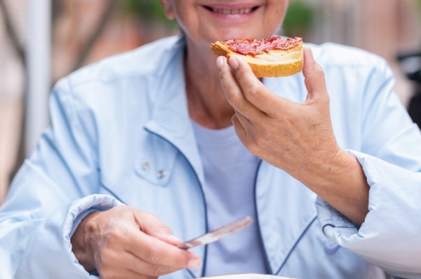 Older woman eating slice of bread lucigerma
