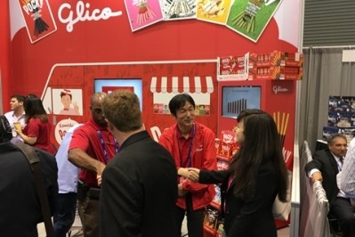 Ezaki Glico USA President Akitoshi Oku, pictured center shaking hands with a woman, at the Sweets and Snacks Expo 2016 in Chicago last month.