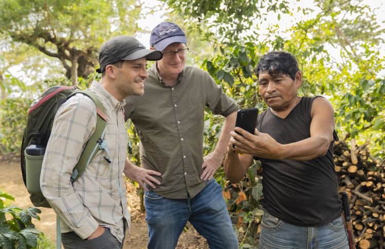 A smallholder farmer in Guatemala shares coffee production information with representatives from Peet's Coffee and Enveritas